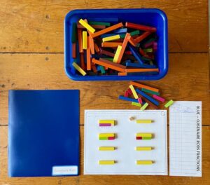 Table with folder, bin of cuisenaire rods, and play mat